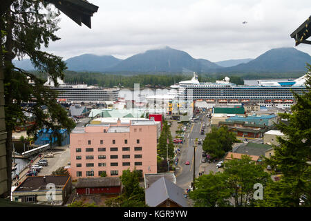 Eine erhöhte Ansicht von Ketchikan, Alaska mit dem Kreuzfahrtschiff Eurodam und Star Princess in den Hintergrund und die Berge und den Wald in der Ferne. Stockfoto