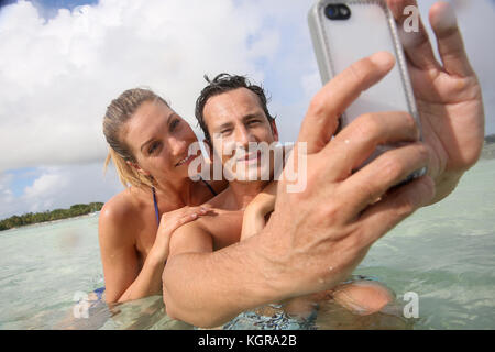 Paar machen selfie im Meer mit wasserdichten Smartphone Stockfoto