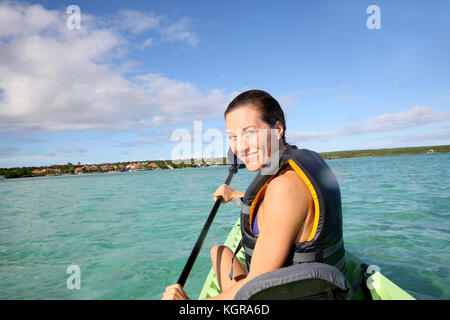 Frau paddeln im Kanu auf der blauen Lagune Stockfoto