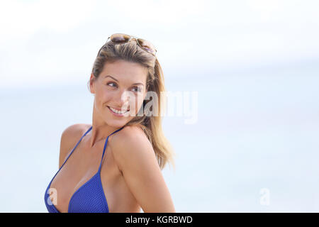 Blonde Frau im Bikini mit Brillen am Strand posieren Stockfoto