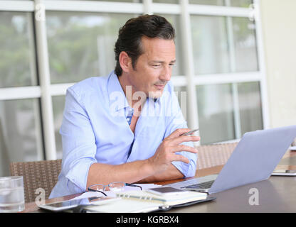 Menschen, die von zu Hause aus arbeiten am Laptop. Stockfoto