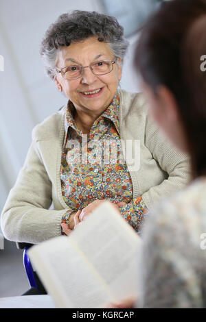 Arer homec lesen Buch alte Frau im Pflegeheim Stockfoto