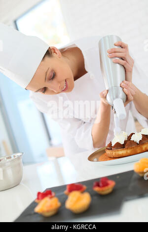 Konditor Verbreitung Sahne auf der Torte Stockfoto