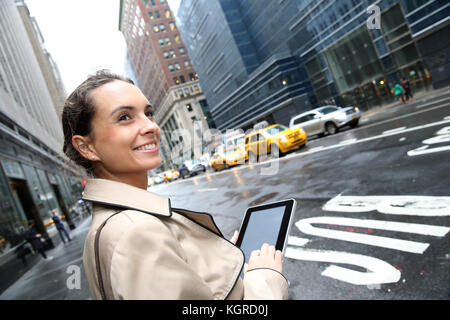 Geschäftsfrau in einer Straße von Manhattan mit Tablet Stockfoto