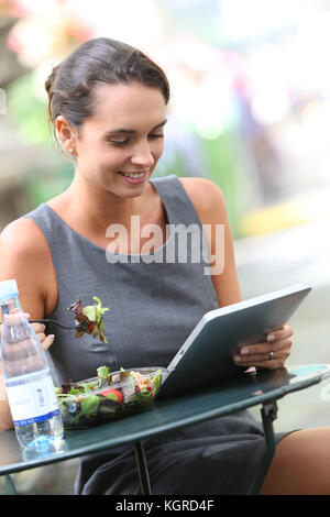 Geschäftsfrau, Arbeiten mit Tablette während dem Mittagessen Stockfoto