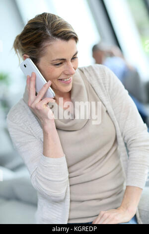 Portrait von Reife blonde Frau am Telefon sprechen Stockfoto