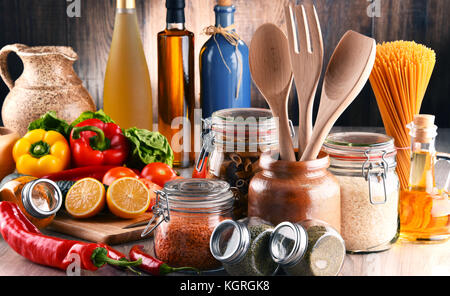 Komposition mit verschiedenen Lebensmitteln und Küchenutensilien auf dem Tisch Stockfoto