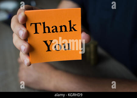 Hand hält eine Orange mit der Aufschrift Danke-Business Konzept Stockfoto