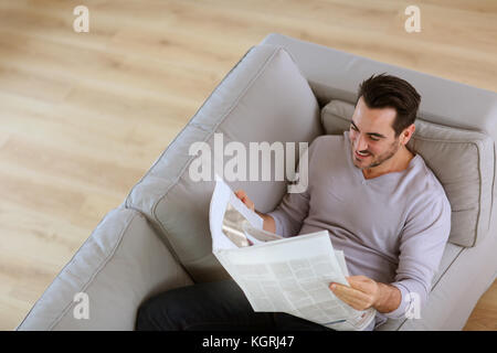 Obere Ansicht des Menschen lesen Zeitung in Sofa Stockfoto