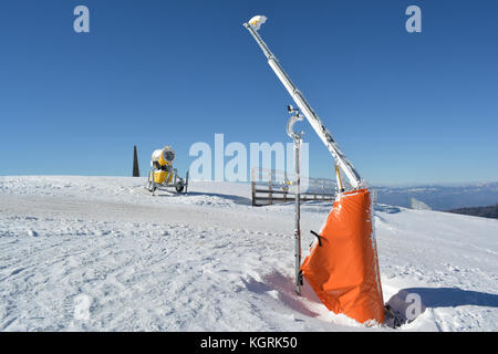 Beginn der Skipisten mit Rampe, hohen Holzzaun, Schneekanone und meteorologische Windmesser montiert auf der Rampe Stockfoto