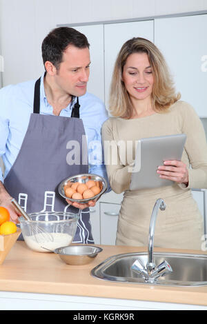 Paar in der Küche auf Rezept im Internet suchen Stockfoto