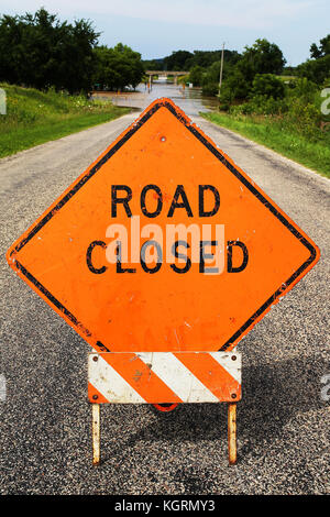 Ein helles Orange Road geschlossene Bauweise Zeichen Warnung Fahrzeuge des blockierten und überschwemmte Straße. Stockfoto