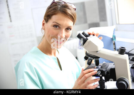 Arzt im Labor durch Mikroskop Stockfoto