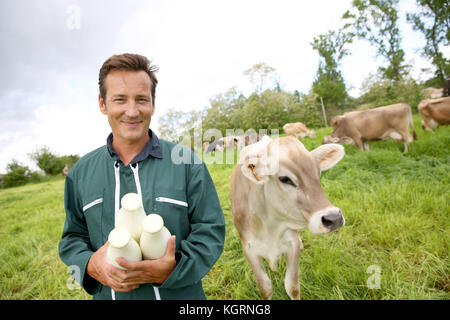 Bauer im Bereich holding Flaschen Milch Stockfoto