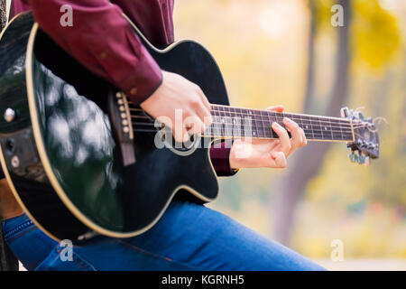 Nahaufnahme, Hände der person Mann spielt akustische Gitarre Künstler Musiker. Konzentrieren Sie sich auf die Finger. Stockfoto