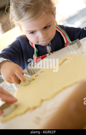 Fröhliches kleines Mädchen Plätzchen backen Stockfoto