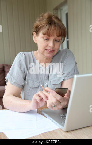 Ältere Frau ausfüllen Formular mit Hilfe des Internet Stockfoto
