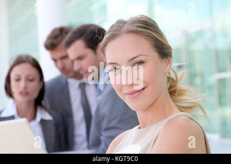 Schöne Geschäftsfrau außerhalb Stehend vor Team Stockfoto