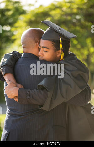 Vater seinen Sohn umarmen bei seinem Abschluss. Stockfoto