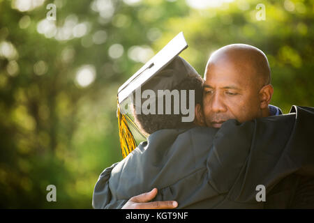 Vater seinen Sohn umarmen bei seinem Abschluss. Stockfoto