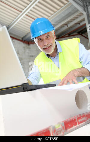 Architekt mit Laptop auf der Baustelle Stockfoto