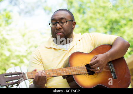 Afrikanische amerikanische Mann spielt eine Gitarre. Stockfoto