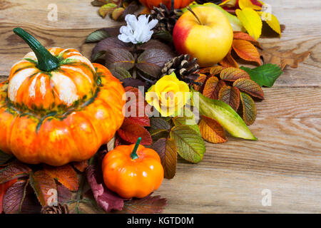 Thanksgiving Dekoration mit Kürbisse, Äpfel, Blätter und Seide Blumen auf den rustikalen Holzmöbeln Hintergrund Stockfoto