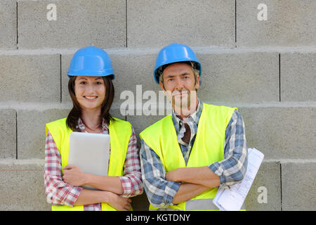 Portrait von lächelnden Bau Team stehend auf Betonwand Stockfoto