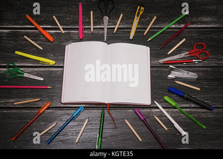 Schreibwaren und Notebook - Bunte Bleistifte und Material Ausrüstung auf Holz- Hintergrund Stockfoto