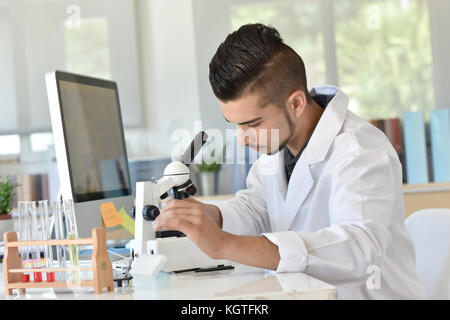 Student der Biologie mit Mikroskop in der Ausbildung Klasse Stockfoto