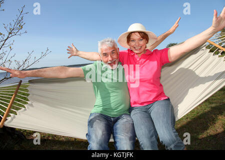 Gerne älteres Paar in einer Hängematte sitzen Stockfoto