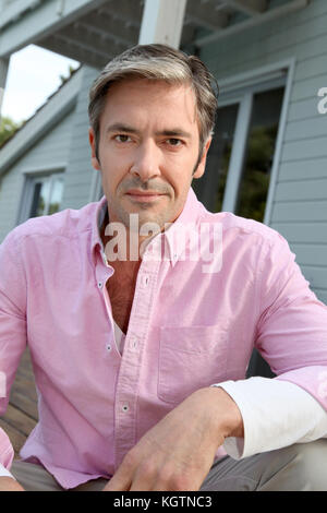 Portrait von lächelnden reifer Mann mit rosa Hemd Stockfoto