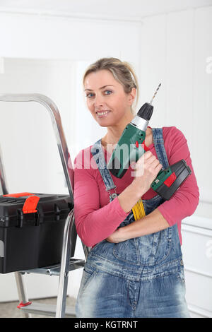 Schöne blonde Frau mit elektrischen Bohrmaschine Stockfoto