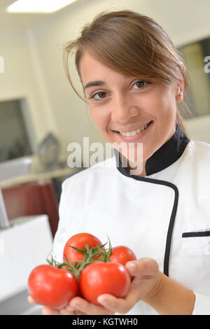 Portrait der Junge Koch Holding Bündel Tomaten Stockfoto