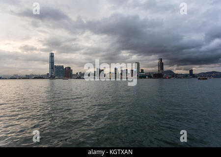 Hong Kong, China - 18. Juni 2017: die Sonne über dem Victoria Harbour und die Skyline von Kowloon in Hong Kong. Stockfoto