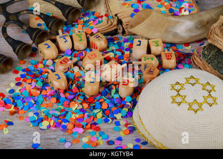 Chanukah Holz- dreidels auf einer Holzoberfläche. Seitenansicht mit den hebräischen Buchstaben Nonne, Gimel, he, Shin. geringe Tiefenschärfe, Schatten. Stockfoto