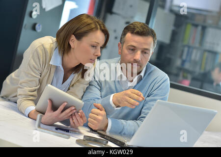 Geschäftsleute im Büro Arbeiten am Notebook und Tablet-PC Stockfoto