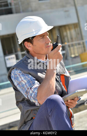 Mann auf der Baustelle mit walkie-talkie Stockfoto