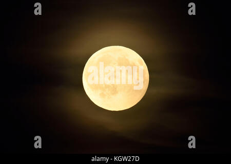 Vollmond/Vollmond scheint in dunkler Nacht, Amber Mond mit einigen wenigen geschwollene, trübe Wolken. Stockfoto