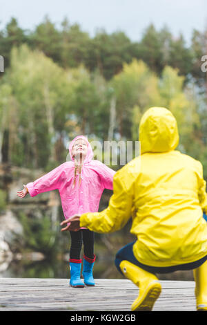 Glückliches Kind in Regenmantel Stockfoto