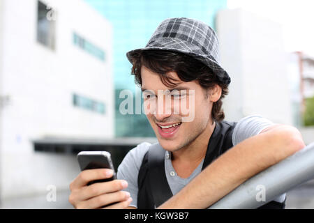 Porträt der jungen Kerl Senden der Nachricht mit Smartphone Stockfoto