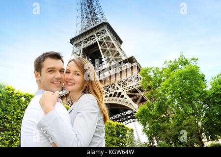 Paar einander umarmen vor dem Eiffelturm Stockfoto