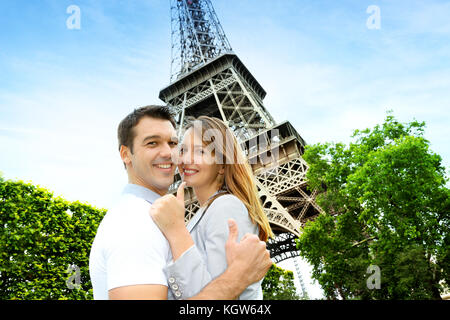 Paar einander umarmen vor dem Eiffelturm Stockfoto