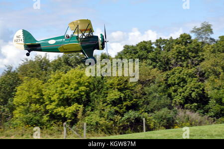 Ein 30er Waco offenen Cockpit Doppeldecker Landung am Flugplatz in der Nähe von antiken Blakesburg, IA Stockfoto