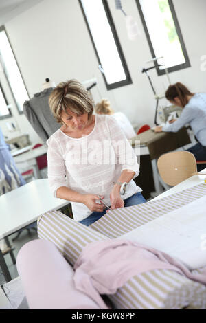 Nahaufnahme der Schneiderin in der Ausbildung Klasse Stockfoto