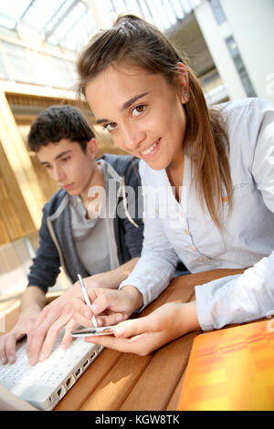 Mädchen in der Hochschule sie ihr Smartphone außerhalb des Klassenzimmers Stockfoto