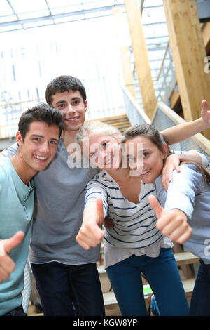 Gruppe von fröhlichen Studenten zeigen Daumen hoch Stockfoto