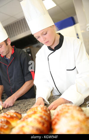 Baker mit Studenten in Küche Gebäck machen Stockfoto