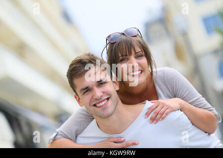 Junger Mann, der piggyback Ride zu Freundin in der Stadt Stockfoto