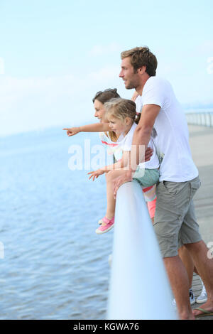 Familie, die auf einem Ponton mit Blick auf das Meer Stockfoto